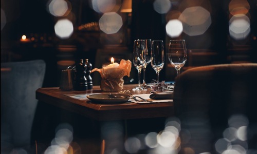 wine glasses and a candle in a warm lit restaurant